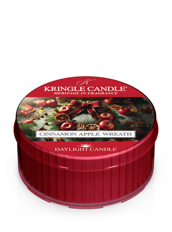 Red Kringle Candle daylight labeled "Cinnamon Apple Wreath Daylight," featuring apple and spice wreath imagery on the lid.
