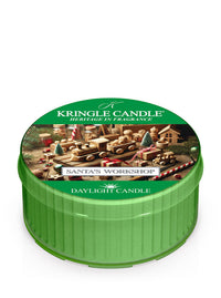 Green daylight of Kringle Candle featuring "Santa's Workshop" design with toys and trees, labeled "Daylight Candle."