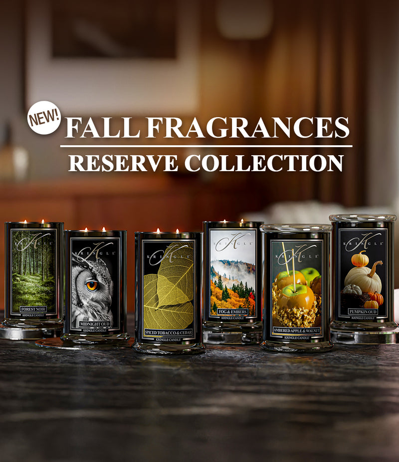 Collection of candles with fall-themed labels on a dark surface, featuring the 'New! Fall Fragrances Reserve Collection' text.