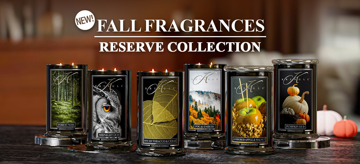 Row of candles with fall-themed labels on a wooden surface, featuring the 'New! Fall Fragrances Reserve Collection' text.