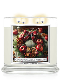 4-wick candle with a Cinnamon Apple Wreath label, featuring apples, cinnamon sticks, and greenery, by Kringle Candle.
