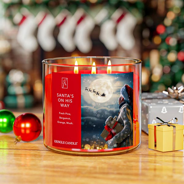 Kringle Candle Christmas-themed candle with Santa Claus design, surrounded by festive decorations.