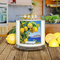 Kringle Candle Aegean Zest 4-Wick Jar Candle – A wide, clear glass jar candle with four lit wicks, filled with white wax. The label showcases vibrant yellow lemons, green leaves, and white blossoms against a deep blue ocean and an island in the background. The ‘Kringle Candle’ logo is displayed at the top, with the fragrance name ‘Aegean Zest’ in bold, and ‘Kringle Candle’ branding at the bottom.