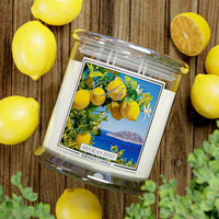 Kringle Candle Aegean Zest 4-Wick Jar Candle – A wide, clear glass jar candle with four lit wicks, filled with white wax. The label showcases vibrant yellow lemons, green leaves, and white blossoms against a deep blue ocean and an island in the background. The ‘Kringle Candle’ logo is displayed at the top, with the fragrance name ‘Aegean Zest’ in bold, and ‘Kringle Candle’ branding at the bottom.