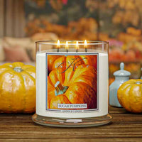 Kringle Candle with 'Sugar Pumpkins' label on a wooden surface with pumpkins in the background