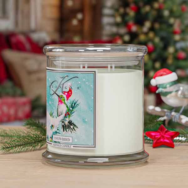 Snowbird 4-wick Candle with a decorative label in a festive setting with Christmas decorations.