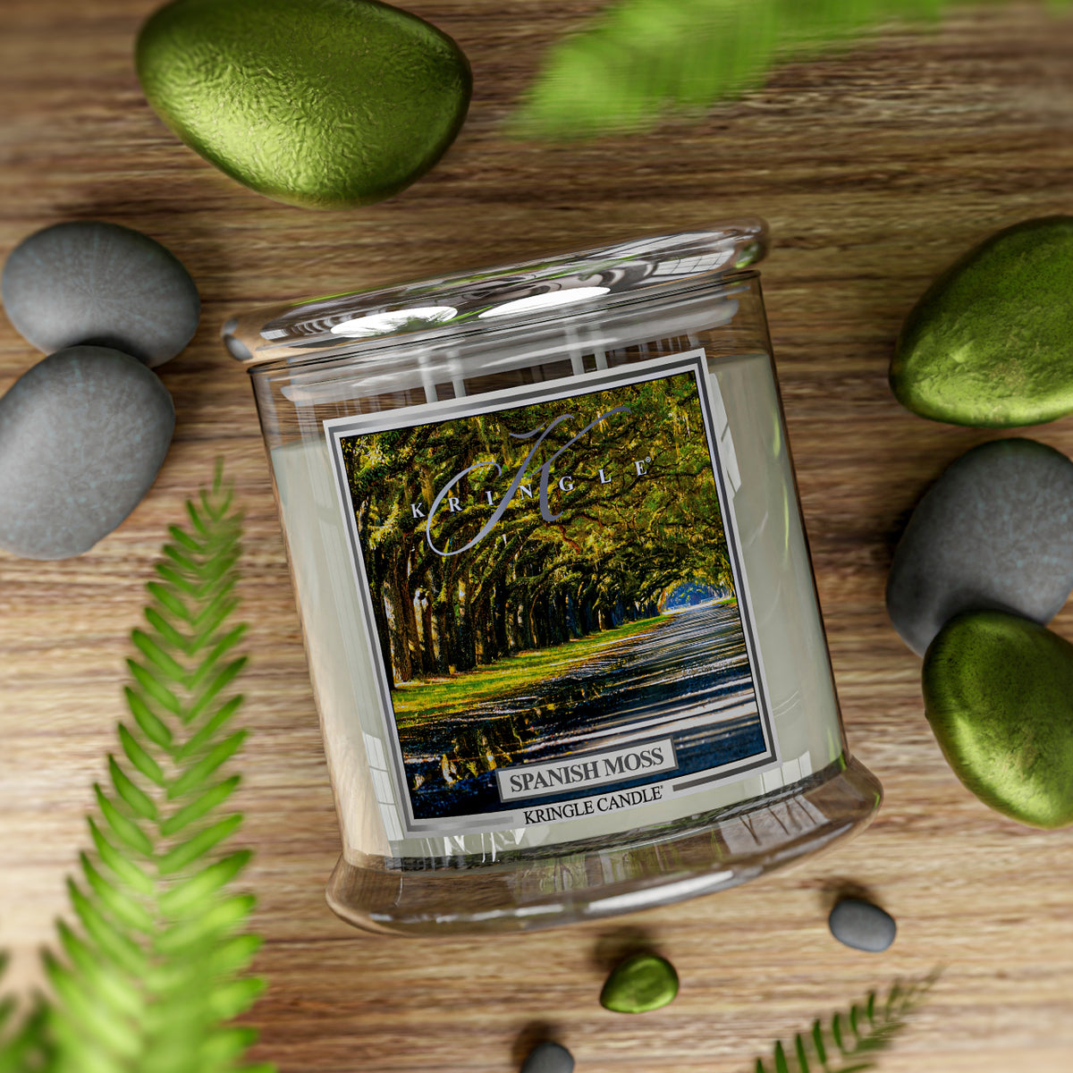 A candle jar with a label showing a tree-lined path. It reads "Spanish Moss, Kringle Candle."