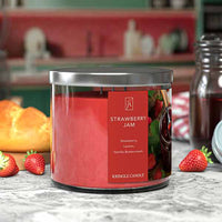 Kringle Candle Strawberry Jam candle on a kitchen counter with strawberries and bread in the background