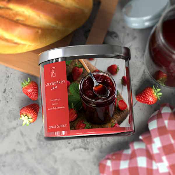 Jar of strawberry jam with a red label on a gray surface, surrounded by strawberries and a loaf of bread.