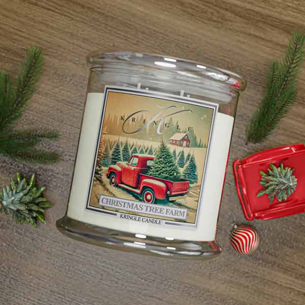 Kringle Candle Christmas Tree Farm candle with decorative elements on a wooden surface