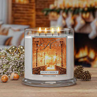 Kringle Candle with 'Snowy Bridge' label on a wooden surface with decorative elements.