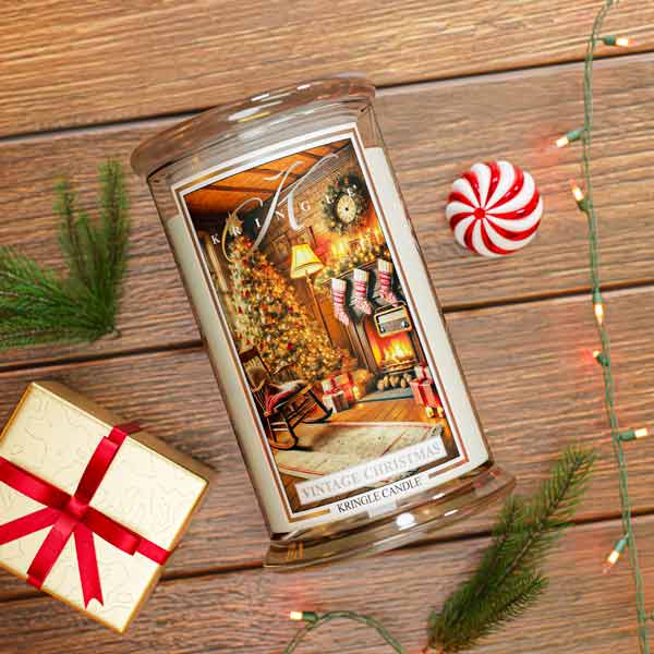 Decorative Vintage Christmas candle with Christmas scene on a wooden surface with a gift and candy cane.