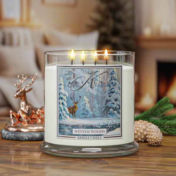 Kringle Candle labeled 'Winter Woods' on a table with decorative elements.
