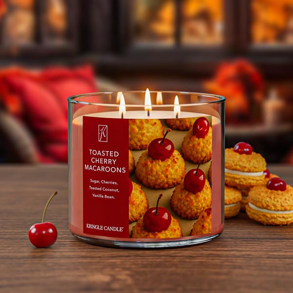 Kringle Candle with 'Toasted Cherry Macaroons' label on a wooden surface with cherry garnish.