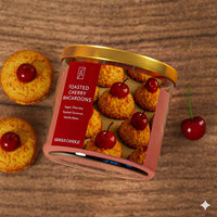 Jar of toasted cherry macaroons with a red label on a wooden surface