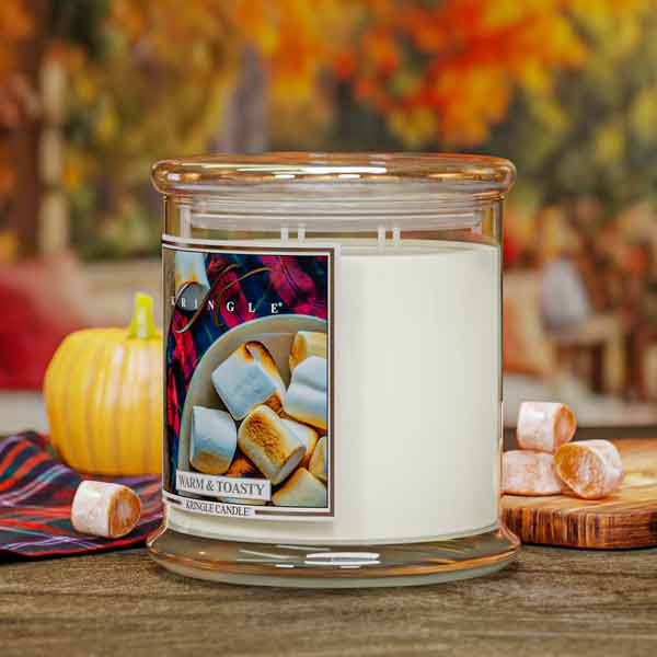 Warm and Toasty Scented Jar candle with marshmallows and pumpkin on a wooden surface
