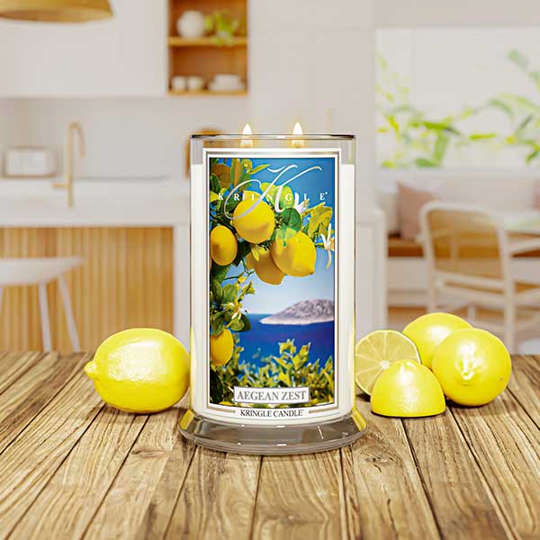 Lit candle labeled "Aegean Zest" with lemons and ocean scene, set in a colorful room with green, yellow decor.
