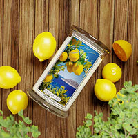 Kringle Candle Aegean Zest Large Jar Candle – A clear glass jar candle with a white wax interior, featuring a label with bright yellow lemons, green leaves, and white blossoms set against a deep blue ocean and an island in the background. The label includes the ‘Kringle Candle’ logo at the top, the fragrance name ‘Aegean Zest’ in bold, and ‘Kringle Candle’ branding at the bottom.