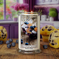 Kringle Candle's Blueberry Muffin scented candle in a large 22oz glass jar with both wicks lit sitting on a kitchen counter.