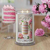 A lit candle labeled "Chiffon Parfait & Peony" with pink floral design, set on a countertop in a pink-themed kitchen.