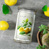 Glass jar candle with label showing yellow yuzu fruits and green leaves. Text: "Yuzu & Sage," "Kringle Candle."