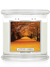 Kringle Candle Autumn Amber 4-wick candle with an autumn scenic label of trees and fall leaves