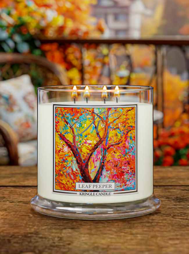 Kringle Candle 'Leaf Peeper' 4-wick candle with colorful label on a wooden surface.