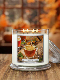 Kringle Candle Butter Rum Cafe candle with a blurred autumn background