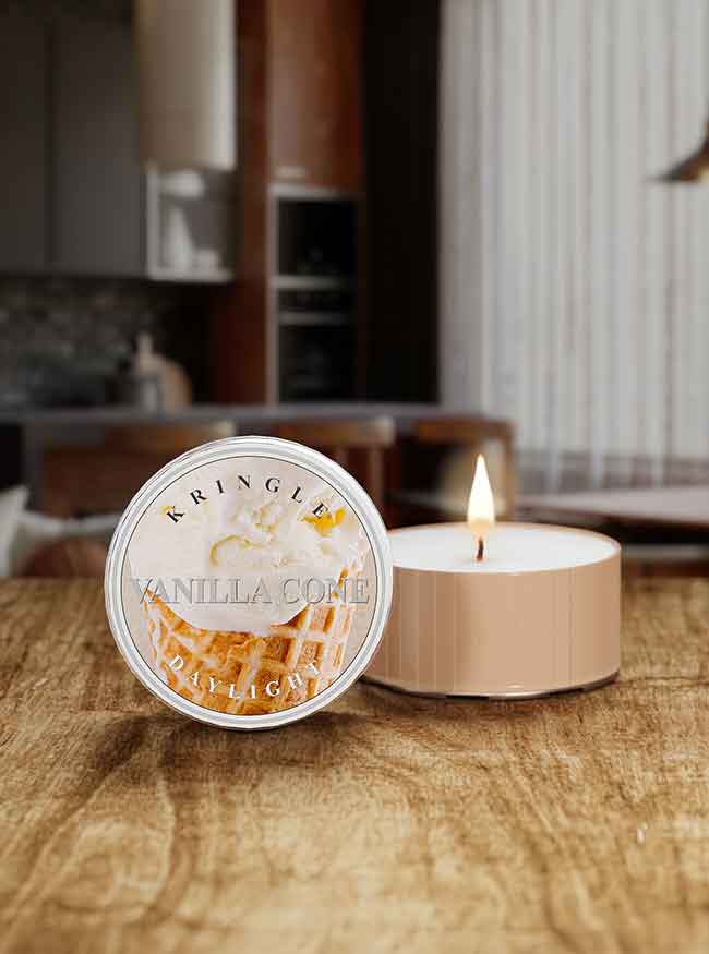 Kringle Candle vanilla cone daylight candle on a wooden surface with a blurred background