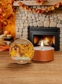 Lit DayLight candle in "Rosewood & Vetiver" scent. Label shows a guitar and autumn leaves.