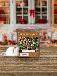 Kringle Candle wax melts packaging on a wooden surface with a festive background