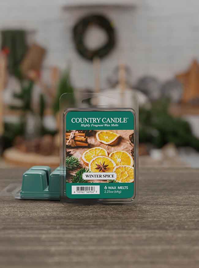 Package of "Country Candle" Winter Spice wax melts with images of oranges and cinnamon on a wooden table.