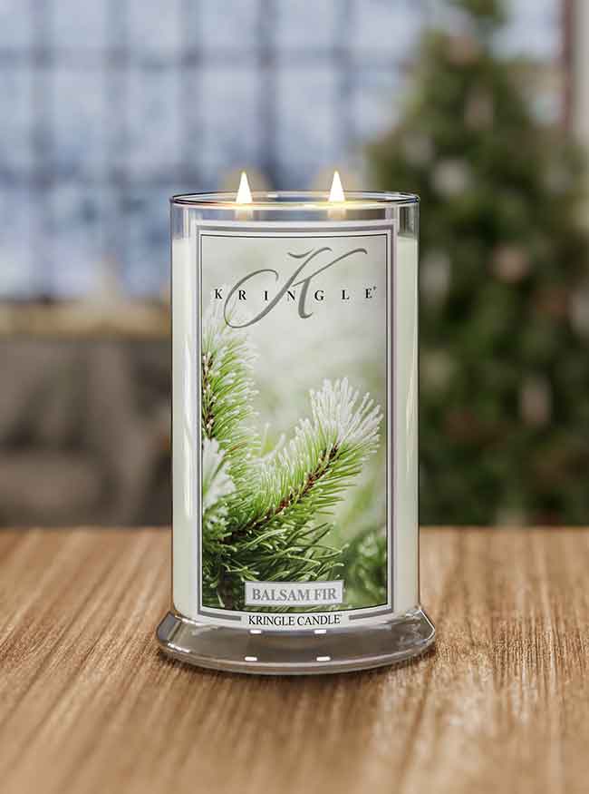 Kringle Candle with 'Balsam Fir' label on a wooden surface with a blurred background