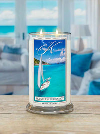 Lit candle with label featuring a sailboat on turquoise sea. Text reads "Sea Salt & Bergamot, Kringle Candle."