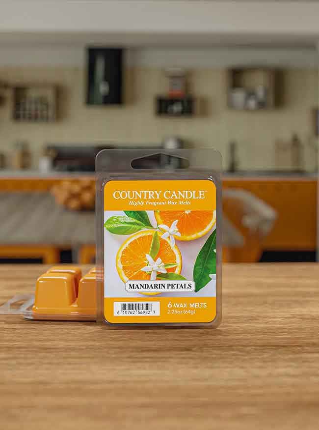 Package of "Country Candle" Mandarin Petals wax melts on a wooden table, with a kitchen in the background.