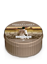 Kringle Candle's Far, Far Away citrus scented Daylight candle with a label showing a man holding a woman's hand and leading her away to take a flight on a prop plane off in the distance.
