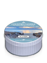 Round candle tin labeled "Country Candle, Seaside Daylight Candle" with a beach scene on lid.