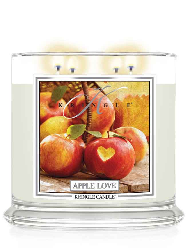 Kringle Candle 4-wick lit with 'Apple Love' design featuring apples on a white background