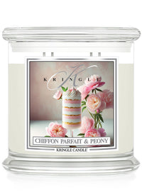 Glass candle jar with label featuring layered dessert, pink peonies, and elegant script reading "Chiffon Parfait & Peony."