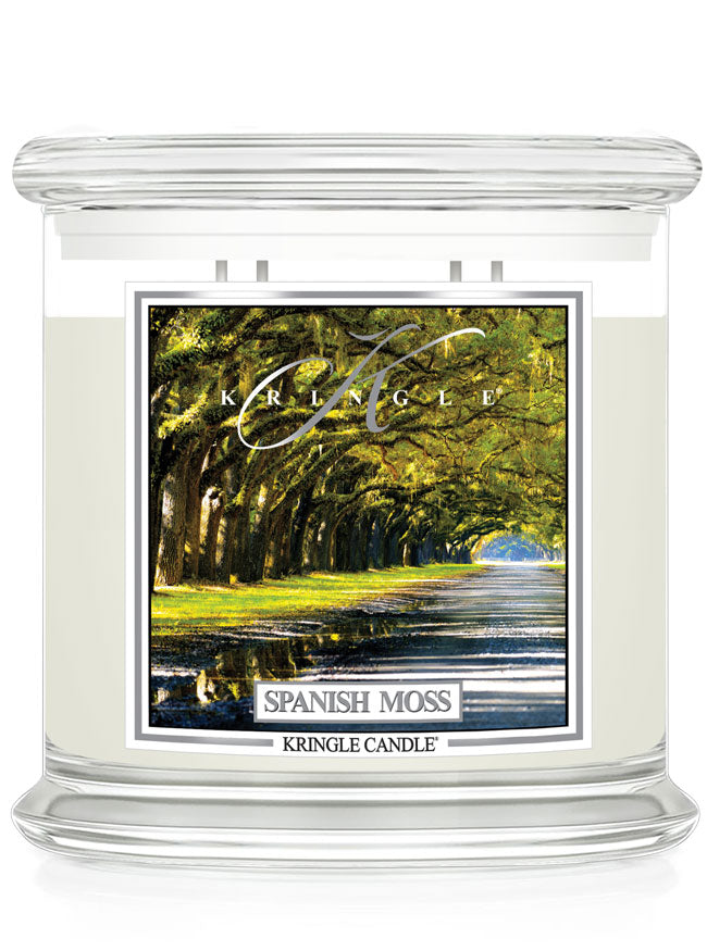 A candle jar with a label showing a tree-lined path. It reads