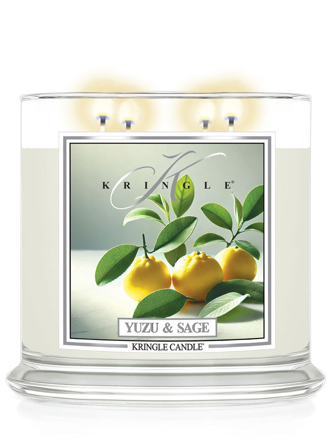 A white three-wick candle labeled "Yuzu & Sage" with an image of yellow yuzu fruits and green leaves on the side.