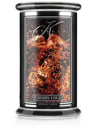 Studio product image of Kringle Candle’s Cherry Cola scented candle in a large jar with a black label and clear glass lid.