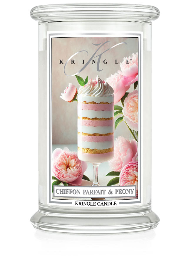 Glass candle jar with a label showing a layered dessert and pink peonies.