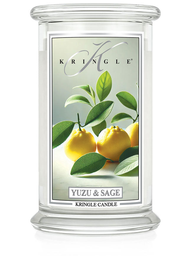 Glass jar candle with label showing yellow yuzu fruits and green leaves. Text: