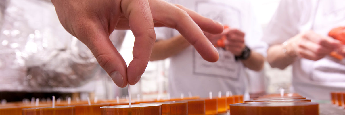 Kringle Staff Straightening candle wicks in candles poured at Kringle Candle