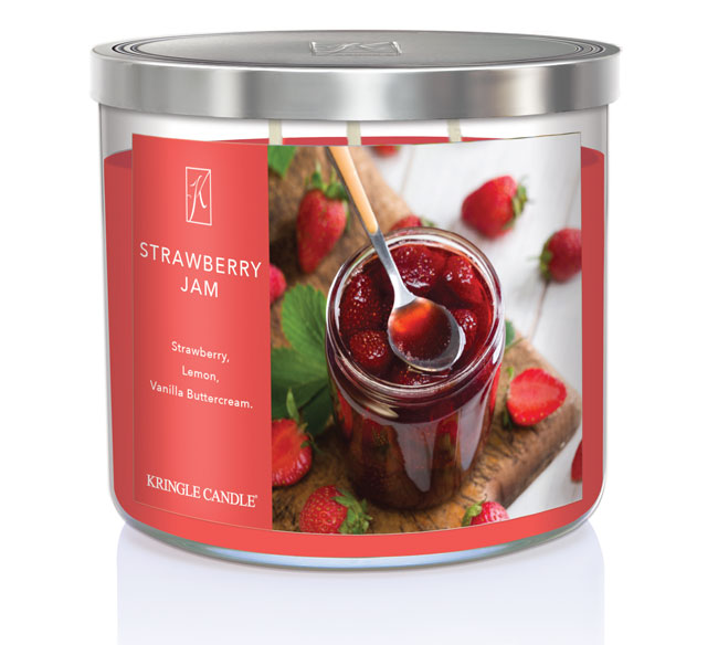 A three-wick candle in a clear glass jar with a black lid and a sweet jam-themed label. The label features a glass jar of strawberry jam with fresh strawberries scattered around. The candle’s wax is deep red, and the wicks are unlit. The scent notes listed are strawberries, tart lemon, and vanilla buttercream.