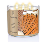 A three-wick lit candle in a clear glass jar with a sophisticated wood-themed label. The candle’s wax is rich brown, and all three wicks are burning.