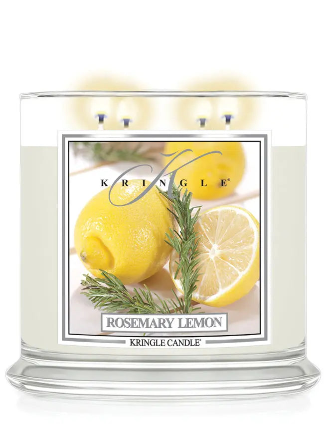 Lit Kringle Candle in Rosemary Lemon scent with glowing flames and label showing lemons and rosemary.