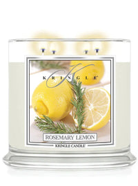 Lit Kringle Candle in Rosemary Lemon scent with glowing flames and label showing lemons and rosemary.