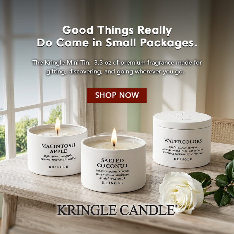 Kringle Candle scented candles on a wooden surface with a window in the background